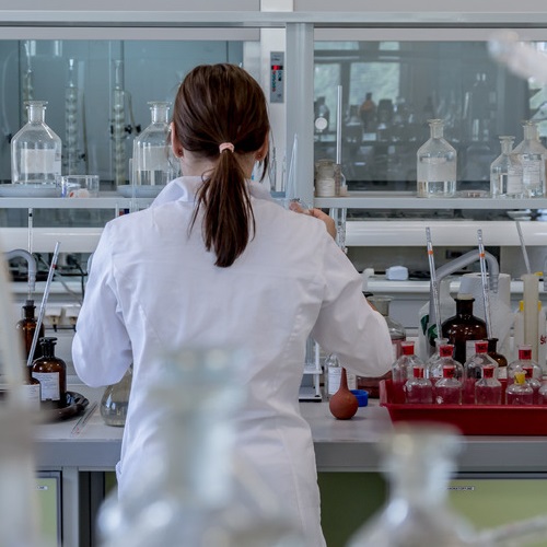 Researcher wearing white lab coat reviewing an experiment